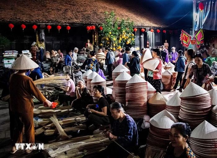 Phiên chợ nón làng Chuông họp theo các ngày 4, 10, 14, 20, 24 và 30 âm lịch hằng tháng, diễn ra từ khoảng 4 giờ 30 đến 7 giờ sáng. (Ảnh: Vân Chi/TTXVN phát)