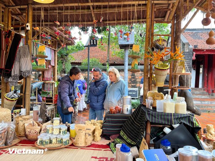 Du khách quốc tế tham quan gian hàng giới thiệu đặc sản vùng miền trong khuôn viên Văn Miếu-Quốc Tử Giám. (Ảnh: Xuân Mai/Vietnam+)