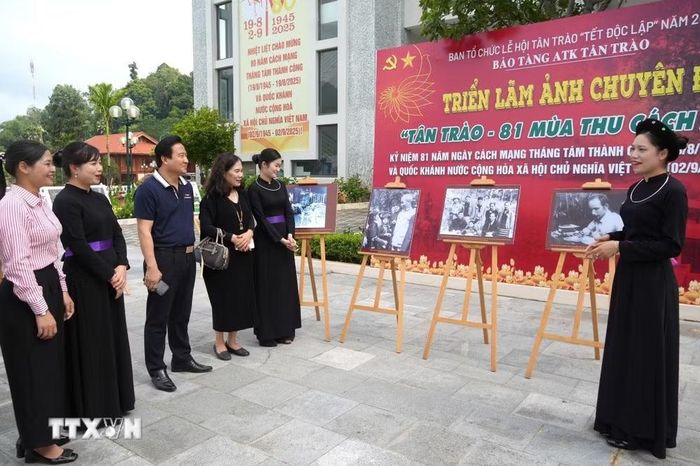 Du khách nghe giới thiệu tại Triển lãm ảnh chuyên đề “Tân Trào - 81 mùa Thu cách mạng” ở Bảo tàng ATK Tân Trào (tỉnh Tuyên Quang). (Ảnh: Minh Tâm/TTXVN)