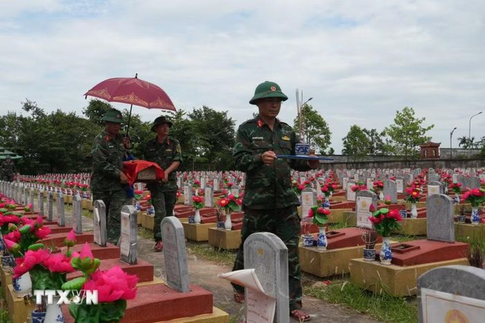 Nhân viên Đội Quy tập Bộ Chỉ huy Quân sự tỉnh Nghệ An khai quật các phần mộ liệt sỹ để lấy mẫu hài cốt. (Ảnh: Bích Huệ/TTXVN)