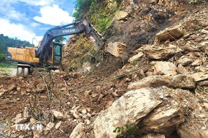 Máy móc san ủi, khai thông tuyến đường tại các điểm sạt lở lớn tại khu vực dốc Nứa, Co Pọng, Xốp Na, Pu Pà Hịa và Co Ngóa. (Ảnh: TTXVN phát)