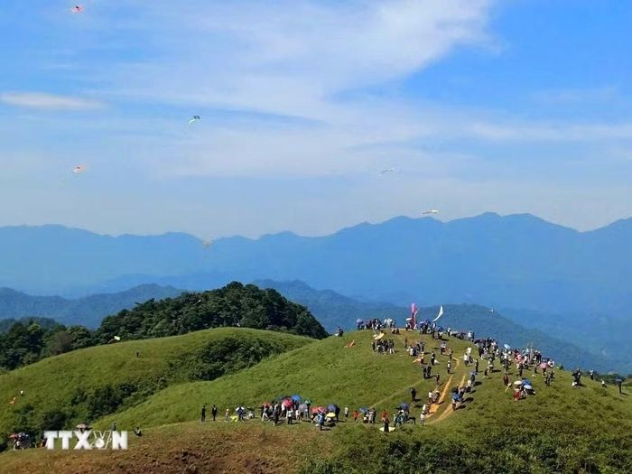 Người dân và du khách tham gia ngày hội, ngắm nhìn những cánh diều được thả trên bầu trời. (Ảnh TTXVN phát)