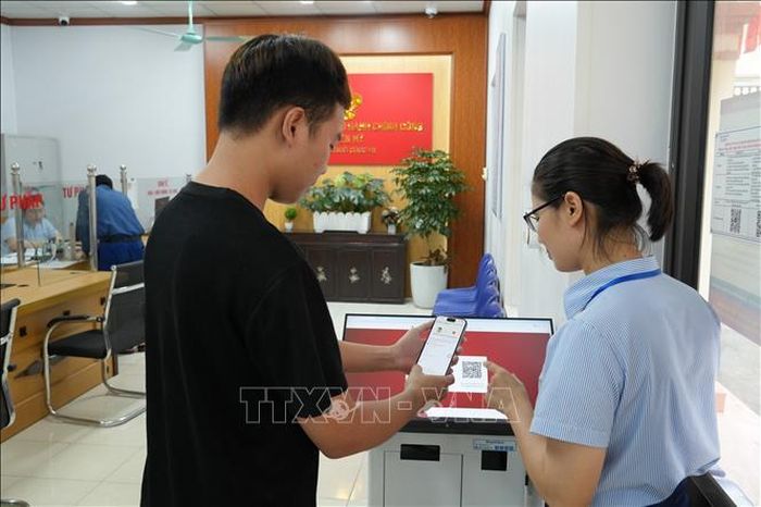Cán bộ Trung tâm phục vụ hành chính công xã Yên Mỹ hướng dẫn người dân nộp hồ sơ qua Cổng Dịch vụ công Quốc gia. Ảnh: Mạnh Khánh/TTXVN