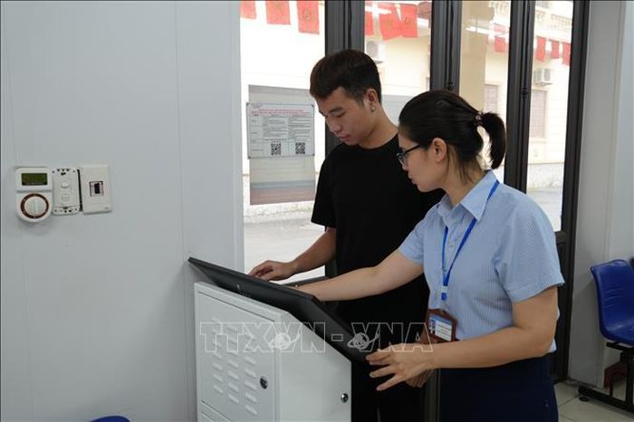 Cán bộ, viên chức Trung tâm phục vụ hành chính công xã Yên Mỹ hướng dẫn người dân nộp hồ sơ qua Cổng Dịch vụ công Quốc gia. Ảnh: Mạnh Khánh/TTXVN