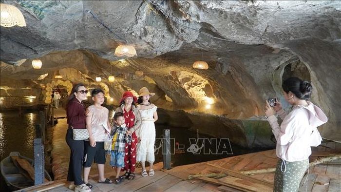 Du khách chụp ảnh lưu niệm trong hang núi Mo So.