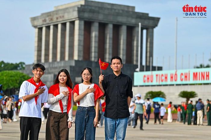 Các bạn trẻ mang Quốc kỳ, lưu lại hình ảnh trước Lăng Chủ tịch Hồ Chí Minh.
