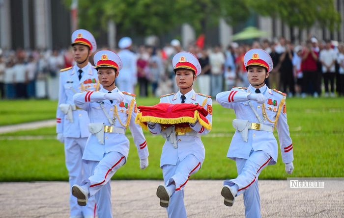 Ba chiến sỹ mang khay đựng quốc kỳ tách khỏi đội hình tiến về cột cờ, chuẩn bị các nghi thức trang trọng.