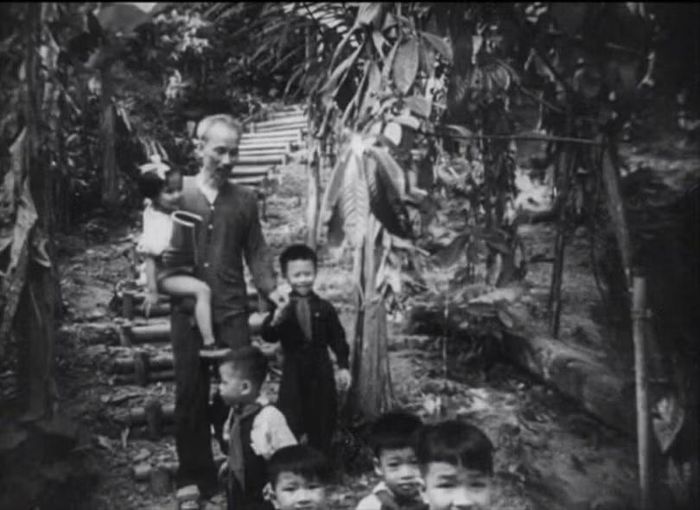 Bác Hồ bế một bé gái và dắt tay cậu bé Hậu năm 1954. Ảnh: NVCC.