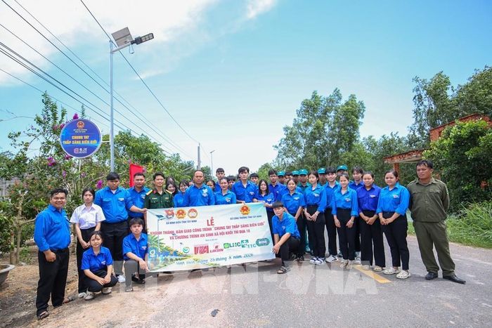 Tuổi trẻ xã Ninh Điền, tỉnh Tây Ninh chung tay hỗ trợ hoàn thiện hệ thống đèn năng lượng mặt trời trên tuyến đường Tuần tra biên giới cho bà con vùng biên giới. Ảnh: Giang Phương - TTXVN