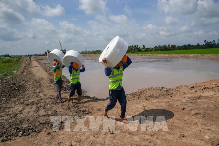 Công nhân vận chuyển vật liệu về công trường ở gói thầu số 1, dự án thành phần 2 cao tốc Châu Đốc - Cần Thơ - Sóc Trăng cuối tháng 8/2026. Ảnh: Thanh Liêm - TTXVN