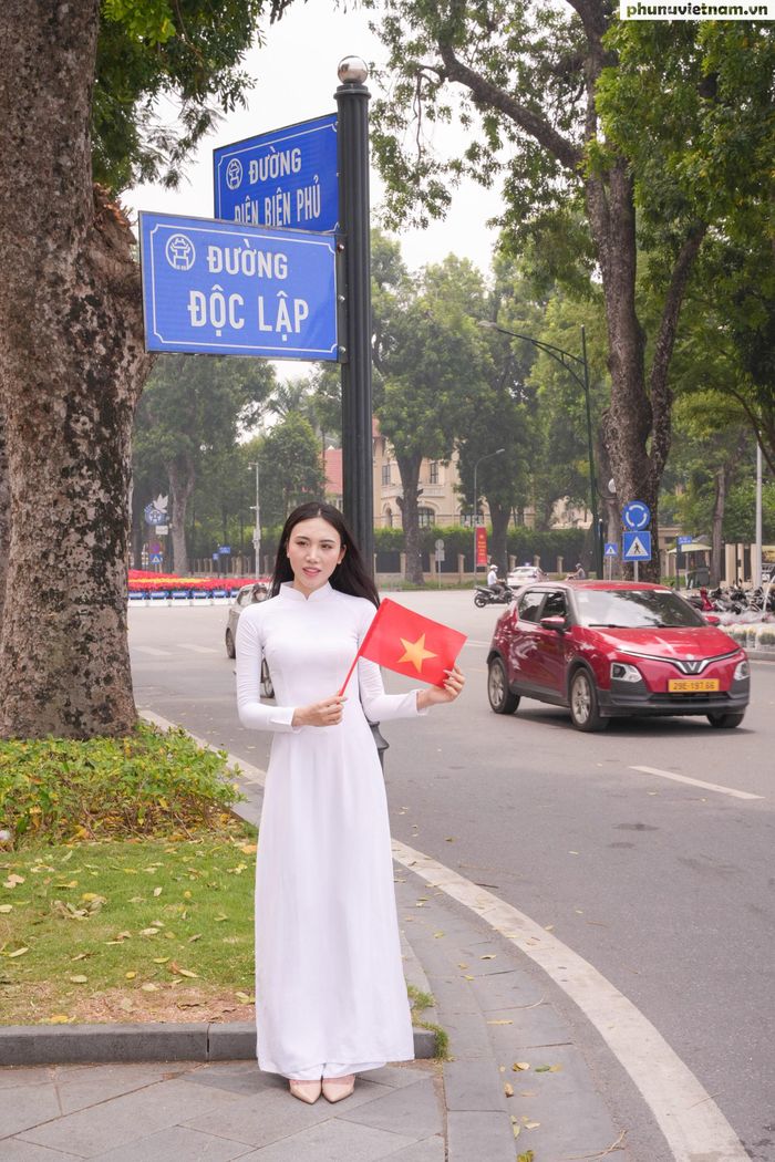 Cô gái cầm lá cờ đỏ sao vàng chụp ảnh tại góc đường Độc Lập - Điện Biên Phủ, khu vực Quảng trường Ba Đình. Người trẻ thể hiện tình yêu quê hương, đất nước qua những khoảnh khắc gần gũi trong dịp lễ trọng đại.