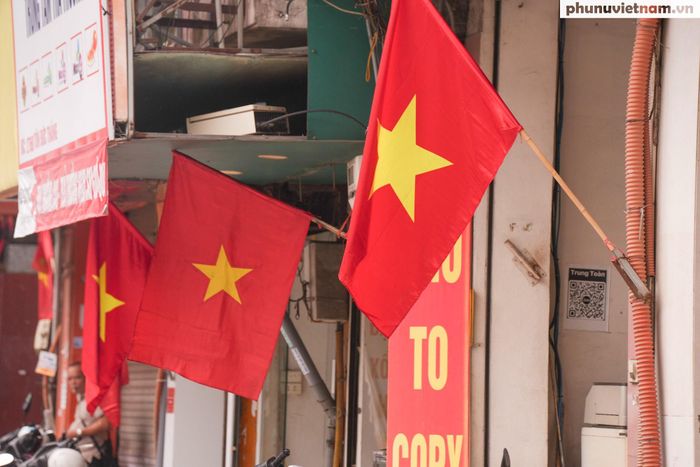 Người dân treo cờ Tổ quốc trước cửa nhà góp phần đưa không khí ngày hội lan tỏa tới từng khu dân cư.