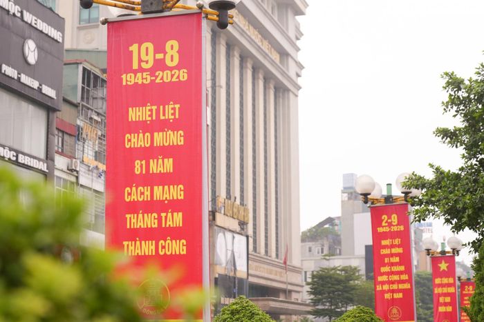 Những hàng banner mang thông điệp chào mừng Cách mạng Tháng Tám và Quốc khánh 2/9 nối dài theo dải phân cách, tô đậm sắc đỏ trên các tuyến phố.