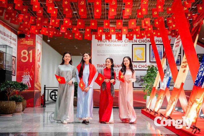 Nhóm bạn trẻ trong trang phục áo dài truyền thống, cầm cờ Tổ quốc chụp hình ở núi Bà Đen.