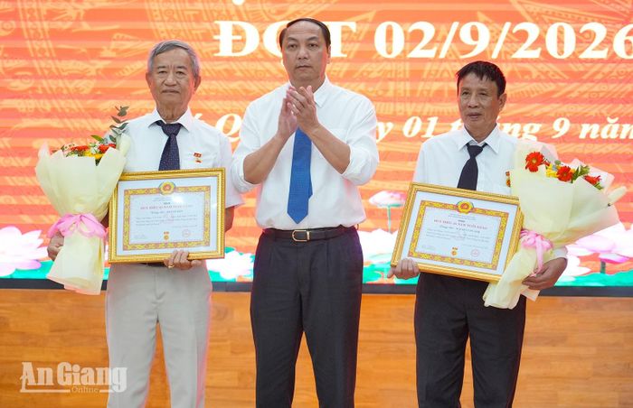 Phó Bí thư Thường trực Tỉnh ủy An Giang Lâm Minh Thành trao Huy hiệu 45 năm tuổi Đảng cho 2 đảng viên cao niên.