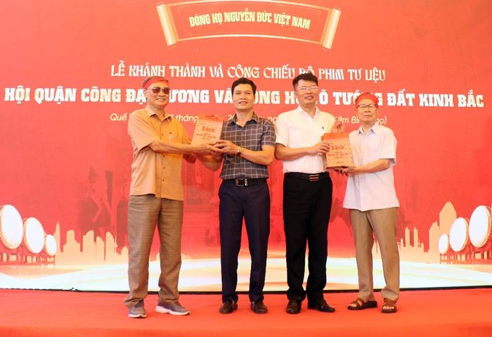  Đại diện dòng họ Nguyễn Đức tặng sách của dòng họ cho đại biểu dự lễ công chiếu phim tư liệu. 