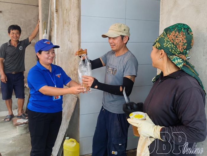Chị Chang Thị Dung (bên trái) động viên công nhân thi công dự án Trường PTNT liên cấp Tiểu học và THCS Sín Thầu.