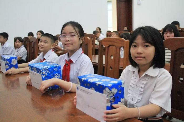 Em Trịnh Thị Minh Thư (giữa) rất vui khi được nhận học bổng. Ảnh: H.H