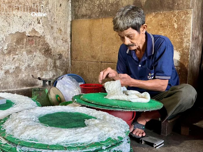 Ông Nguyễn Lễ gỡ bánh sau khi hấp chín, chuẩn bị cho những phần bánh mới.