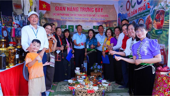Ban giám khảo và các thành viên của đội thi Tổ dân phố số 2, xã Than Uyên chụp ảnh bên mâm cơm dự thi.