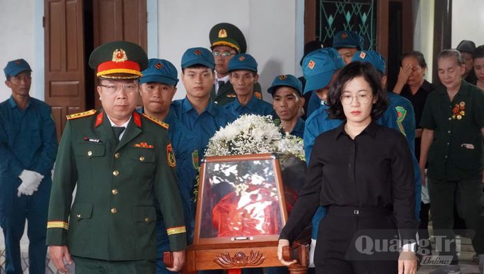 Đại diện lãnh đạo Bộ Chỉ huy Quân sự tỉnh và phường Bắc Gianh di chuyển hài cốt liệt sĩ Nguyễn Quốc Hội về nơi an táng - Ảnh: N.M