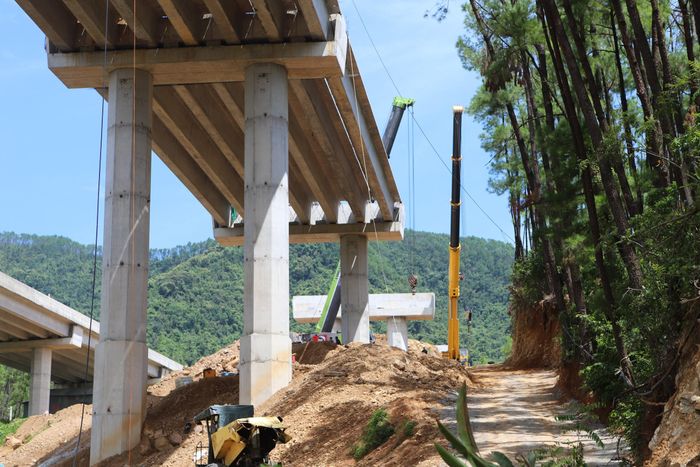 Tại vị trí trụ cầu T13-T14 của cầu Thần Vũ, nơi chênh vênh giữa vai phải của dãy Thần Lĩnh, nhóm kỹ sư công nhân của Tổng công ty Xây dựng Cầu 75 đang thực hiện cẩu lắp nhịp dầm 14.