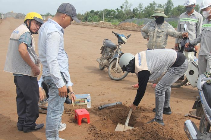 Các kỹ sư cùng tư vấn giám sát kiểm tra độ chặt nền đường sau khi dỡ tải, trước khi trải đá cấp phối đá dăm.