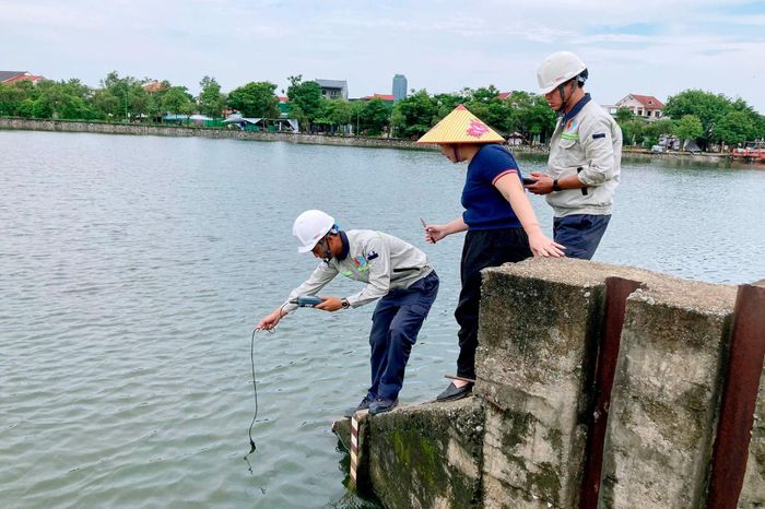 Cơ quan chức năng lấy mẫu nước để xác định nguyên nhân cá chết. Ảnh: Đình Việt