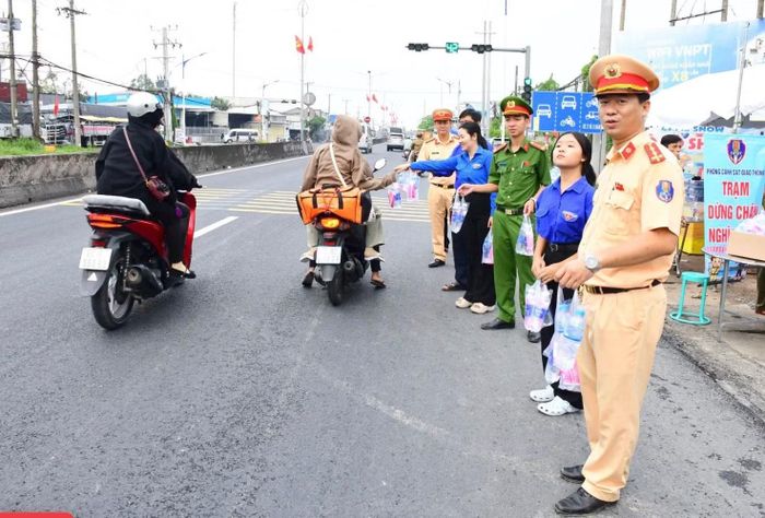 Lực lượng Công an, đoàn viên thanh niên phát nước suối và khăn lạnh tặng người dân.