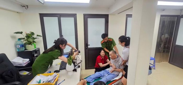 Cán bộ Công an phường phối hợp cùng người thân hỗ trợ chụp ảnh chân dung làm CCCD cho anh H.