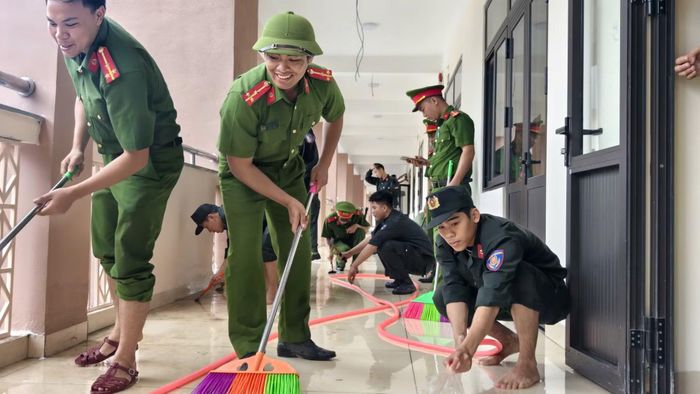 Các đoàn viên, thanh niên Công an TP Huế khẩn trương chùi rửa hành lang các phòng học để giúp học sinh vùng biên đón khai giảng trong ngôi trường sạch sẽ.
