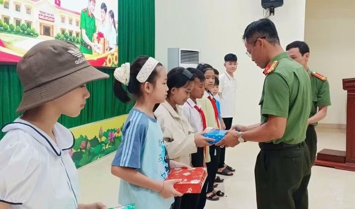 Trung tá Đoàn Văn Tương, Phó Trưởng Công an xã Ea Wer tặng quà cho các em học sinh tại buổi gặp mặt.
