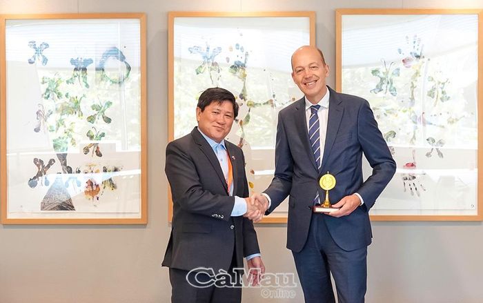 Phó Chủ tịch UBND tỉnh Cà Mau Lê Văn Sử tặng quà lưu niệm của tỉnh Cà Mau đến ông Michiel van der Pompe, đại diện Vụ Phát triển kinh tế bền vững, Bộ Ngoại giao Hà Lan.