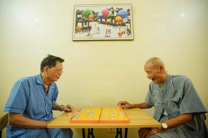 Các cụ ông chơi cờ vui vẻ.