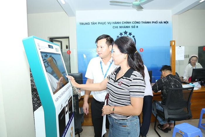 Cán bộ Trung tâm Phục vụ hành chính công thành phố Hà Nội, Chi nhánh số 8 hướng dẫn người dân làm thủ tục hành chính. Ảnh: Công Hùng