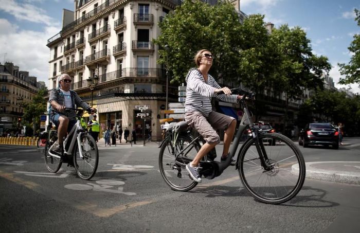 Một người phụ nữ đi xe đạp điện tại Paris, Pháp. Ảnh: Reuters