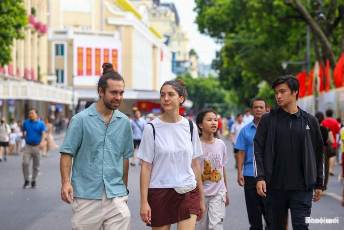 Dưới những hàng cây mát rượi ven hồ, du khách vừa dạo chơi, vừa trò chuyện thích thú.