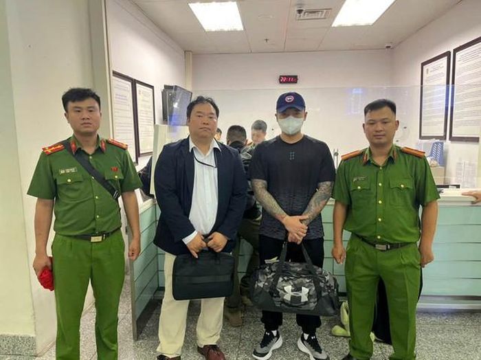 Lực lượng công an bàn giao đối tượng Lee Sammin cho phía Hàn Quốc (áo đen, đứng thứ 3 từ trái sáng). Ảnh: CAHN