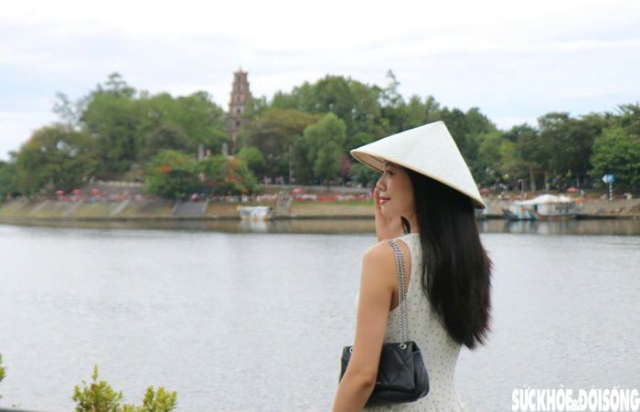 Trang phục cũng trở thành điểm nhấn trong những khung hình. Bên cạnh trang phục trẻ trung, nhiều bạn nữ lựa chọn áo dài, kết hợp nón lá để tạo nên những bức ảnh mang nét đặc trưng của Huế. Ảnh: H.D.
