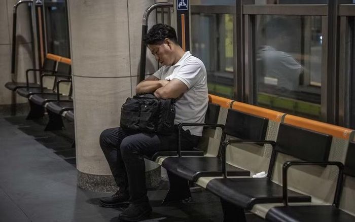 Một nhân viên tranh thủ chợp mắt trên tàu điện tại Tokyo, Nhật Bản