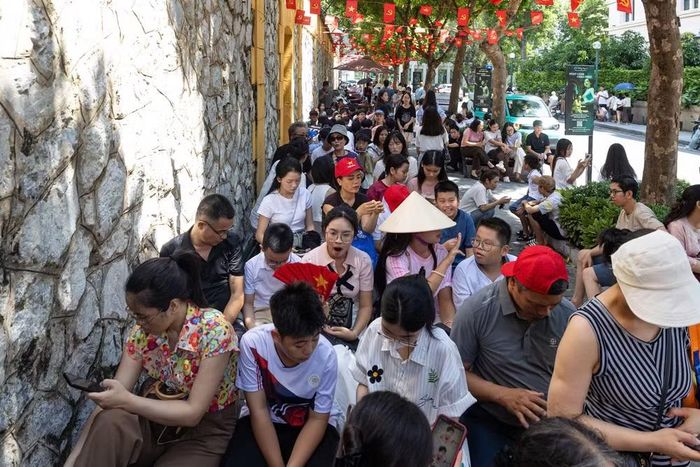 Dù thời tiết nắng nóng, đông đảo người dân và du khách vẫn kiên nhẫn ngồi chờ đến lượt vào tham quan Di tích Nhà tù Hỏa Lò trong dịp Quốc khánh 2/9