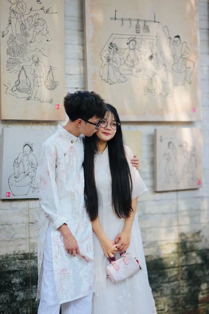 Đôi bạn trẻ mặc áo dài chụp ảnh kỷ niệm trong không gian đậm đặc sắc màu truyền thống