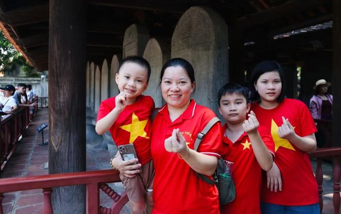 Gia đình mặc đồng phục cờ đỏ sao vàng chụp ảnh, ghi đấu chuyến tham quan Văn Miếu - Quốc Tử Giám đúng ngày Quốc khánh 2-9
