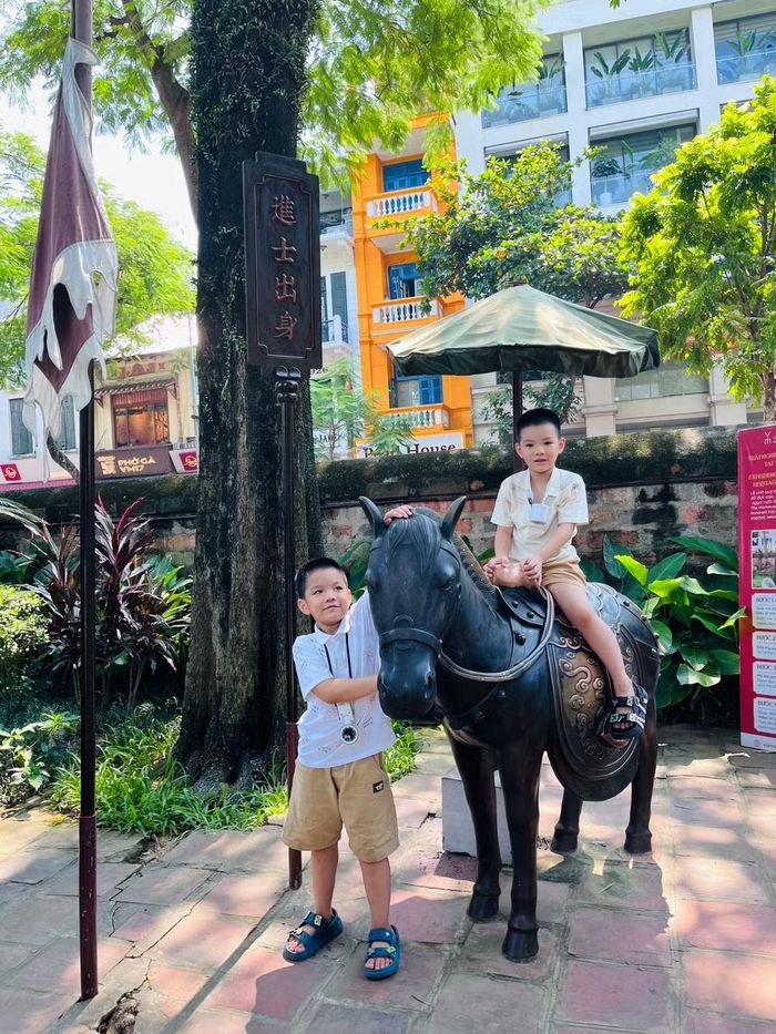 Hai em nhỏ thích thú "Cưỡi ngựa vinh quy bái tổ"