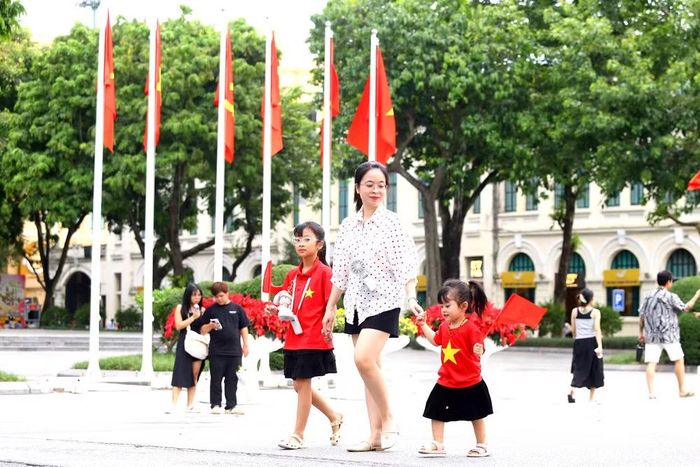 Hình ảnh em nhỏ mặc áo cờ đỏ sao vàng, nắm tay mẹ dạo phố tạo nên khoảnh khắc đáng yêu giữa không khí Quốc khánh