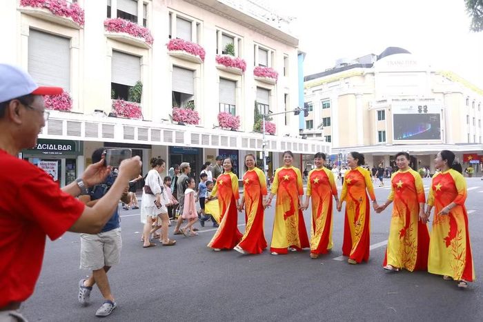 Nhiều người dân trong tà áo dài, tranh thủ ghi lại những khoảnh khắc đáng nhớ giữa không gian Hồ Gươm.