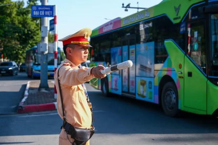 ​Tại ngã tư phố Đại Cồ Việt giao Giải Phóng, lực lượng làm nhiệm vụ liên tục chỉ dẫn các tuyến xe buýt lớn đi sát mép đường, đảm bảo lộ trình thông suốt và an toàn cho các phương tiện nhỏ đi cùng chiều.