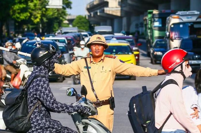 Dưới trời nắng gắt, cán bộ chiến sĩ đội mũ mềm ứng trực giữa tâm đường Giải Phóng, liên tục dùng còi và gậy chỉ huy nắn dòng ô tô kéo dài từ hướng bến xe Nước Ngầm.