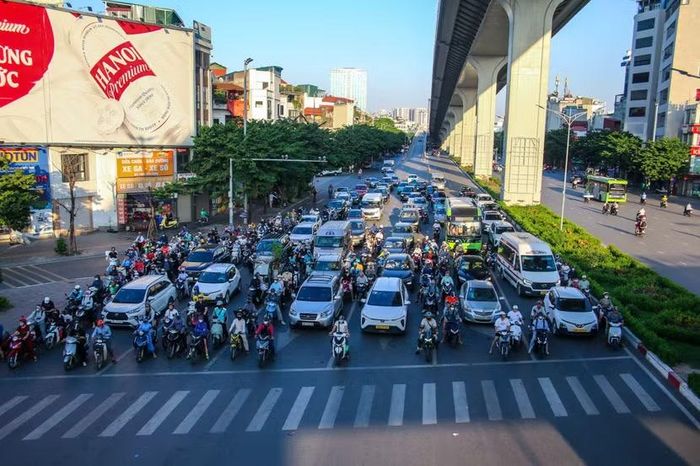 Toàn cảnh dòng ô tô và xe máy dừng chờ đèn đỏ ngăn nắp dưới chân cầu vượt đường sắt trên cao trục Giải Phóng, mật độ phương tiện dày đặc nhưng không xuất hiện cảnh chen lấn, lấn làn.