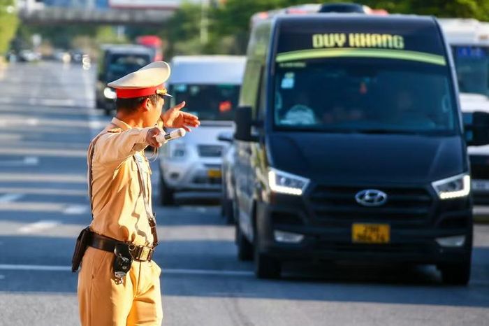 Tại điểm tiếp nhận phương tiện từ cao tốc Pháp Vân vào Giải Phóng, Cảnh sát giao thông ra hiệu lệnh hướng dẫn xe khách đi đúng làn quy định, ngăn phương tiện dừng đỗ đón trả khách tùy tiện.